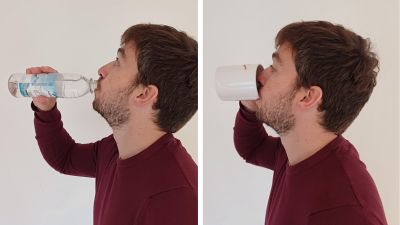 Ein Mann trinkt aus Flasche und Tasse und hebt dabei den Kopf zum Schlucken